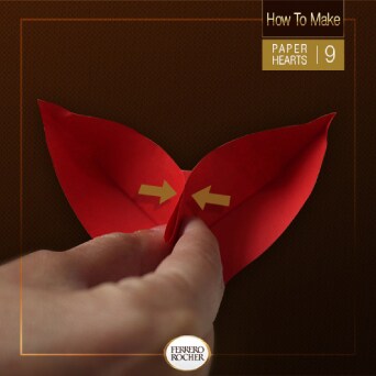 Pinch the sides of the top fold of the middle point onto itself.