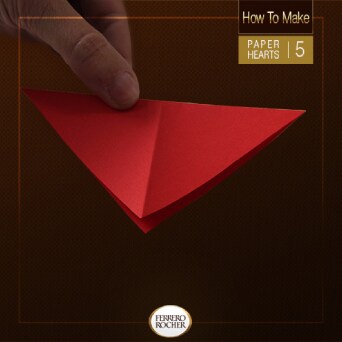 Fold one side of the square into a triangle again and turn the paper so it's "pointing" toward you.